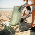Tucking a towel into the back pocket of the TidalDrift pastel green mosaic backpack beach chair.